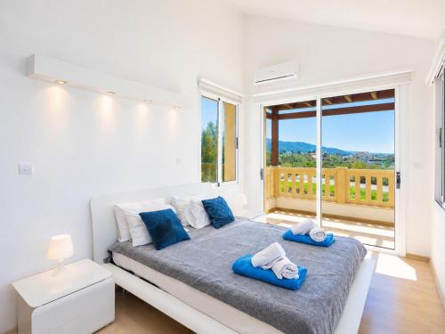 a bedroom with a bed and a large window at Villa Myla in Kato Yialia