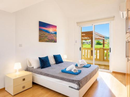 a bedroom with a bed and a large window at Villa Myla in Kato Yialia