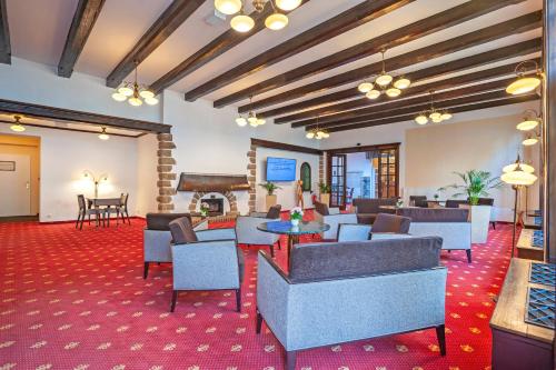 a hotel lobby with couches and a piano at Hotel Luisa in Františkovy Lázně