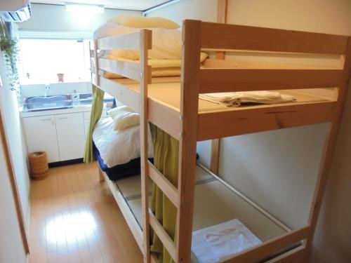 a bunk bed in a room with a kitchen at Guesthouse Oasis in Osaka