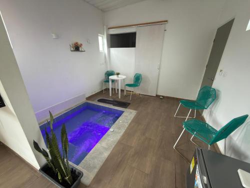 a swimming pool in a room with chairs and a table at Villa campestre Las Palmas in Calima