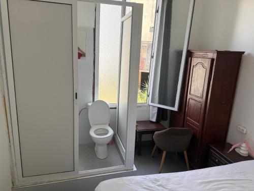 a small bathroom with a toilet and a mirror at Pension Gibraltar in Tangier