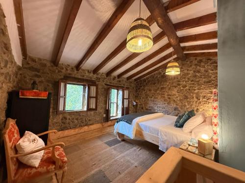 a bedroom with a bed in a room with stone walls at La aldea de lug in Rozagás