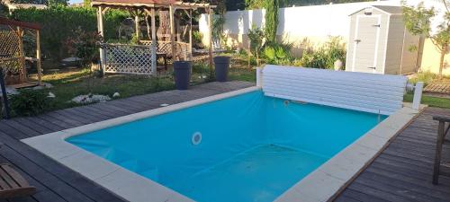 a small blue swimming pool with a bench on a deck at Le cocon in Carpentras