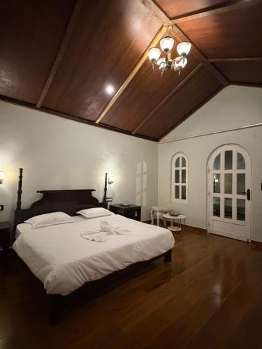 a bedroom with a large bed with a wooden ceiling at Vanvaas the forest note in Godarpura