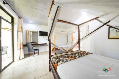 a bedroom with a bed and a desk and a chair at Tan-Swiss Lodge in Mikumi