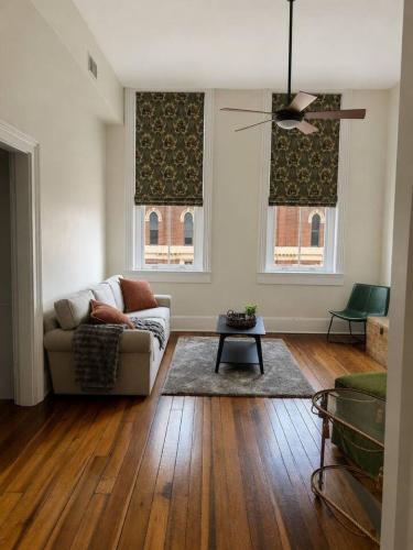 a living room with a couch and two windows at Modern Main Street Charm in Georgetown