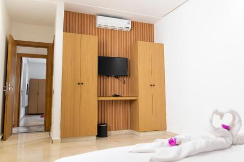 a room with a bed with a tv on a wall at Rose Garden Resort & Spa in Marrakesh