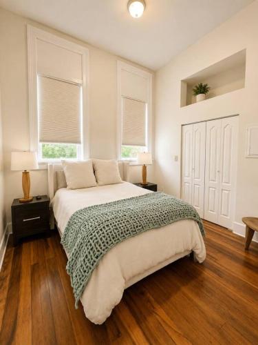 a bedroom with a large bed and two windows at Main Street Stay in Georgetown