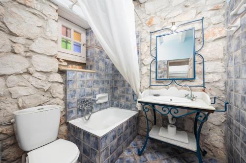 a bathroom with a sink and a toilet and a mirror at Villa Demetra in Áyios Dhimítrios