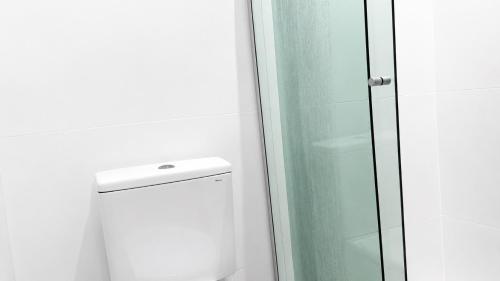 a bathroom with a glass shower and a toilet at Studios Congresso suites e Lofts Duplex in Brasília