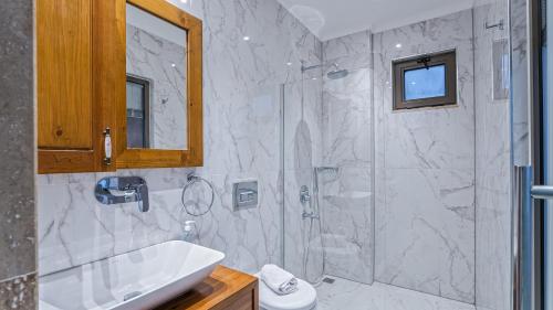 a white bathroom with a shower and a sink at Secluded Sea-View Family Escape-Villa Bella2 Sardunya in Üzümlü