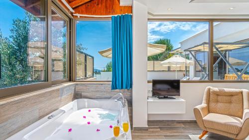 a living room with a tub and a chair at Secluded Sea-View Family Escape-Villa Bella2 Sardunya in Üzümlü