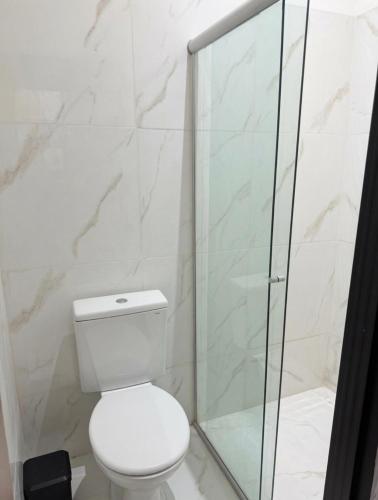 a bathroom with a toilet and a glass shower at Studios Congresso suites e Lofts Duplex in Brasília
