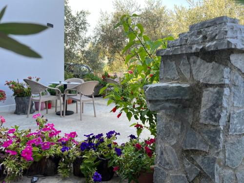 a patio with flowers and a table and chairs at Aloju Rooms in Vlorë