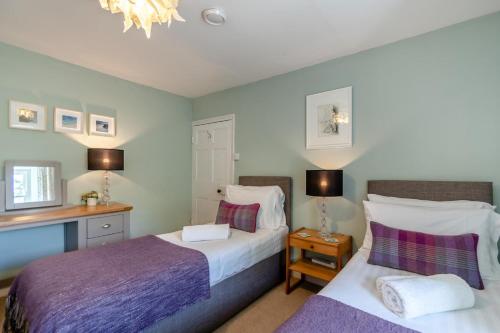 a bedroom with two beds and a desk at 3 Bed in Castlemorris oc-94522 in Castlemartin