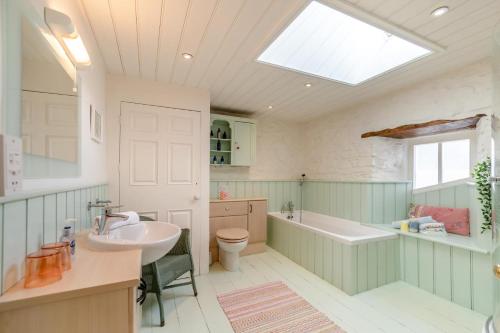 a bathroom with a sink and a tub and a toilet at 3 Bed in Castlemorris oc-94522 in Castlemartin