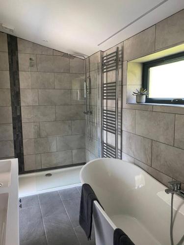 a white bath tub in a bathroom with a window at Egret Woody Park in Willand