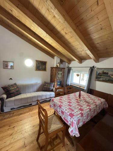 a living room with a table and a couch at Cèsa Niki in Canazei