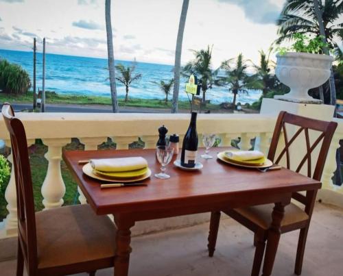 a table with a bottle of wine and a view of the ocean at Samsara in Galle