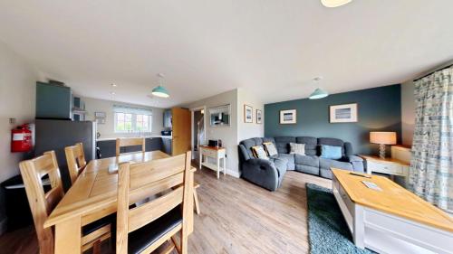 a living room with a couch and a table at Ocean Cove - Part of the The Bay Filey Holiday Village with pool, gym and direct beach access, pub, restaurant, tennis and meadows walks in Reighton