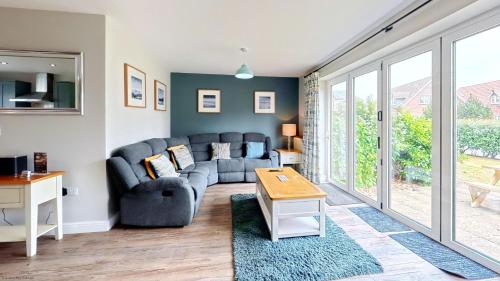a living room with a couch and a table at Ocean Cove - Part of the The Bay Filey Holiday Village with pool, gym and direct beach access, pub, restaurant, tennis and meadows walks in Reighton