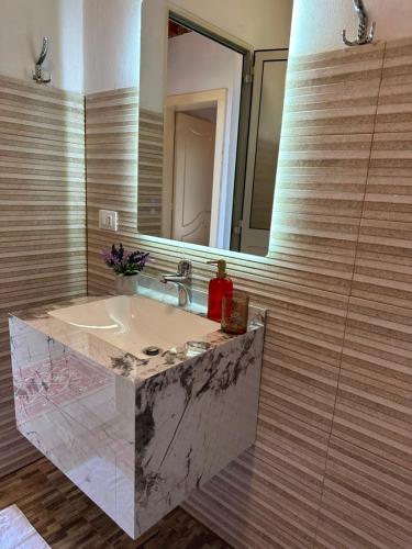 a bathroom with a marble sink and a mirror at Guest House Keli in Nënshat