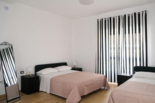 a bedroom with two beds and a large window at Aura Apartments in Pompei