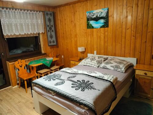 a bedroom with a bed and a table and a chair at U Stenia in Murzasichle