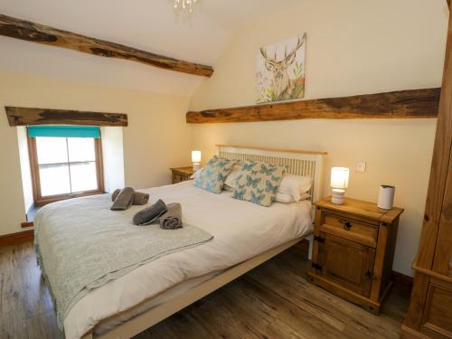a bedroom with a bed in a room with wooden floors at Cornel Clyd in Llanddulas