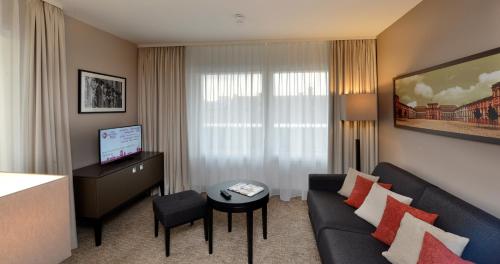 a living room with a couch and a table at Best Western Plus Delta Park Hotel in Mannheim