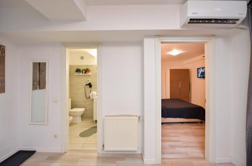 a room with a bathroom with a bed and a toilet at Harmony Suites in Bucharest