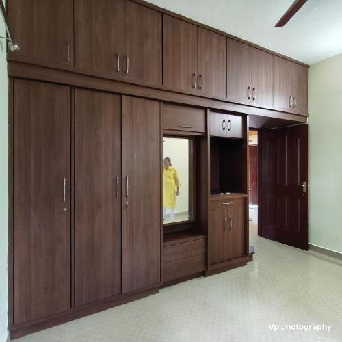 a row of wooden cabinets in a room at Trinity Mansion in Mangalore