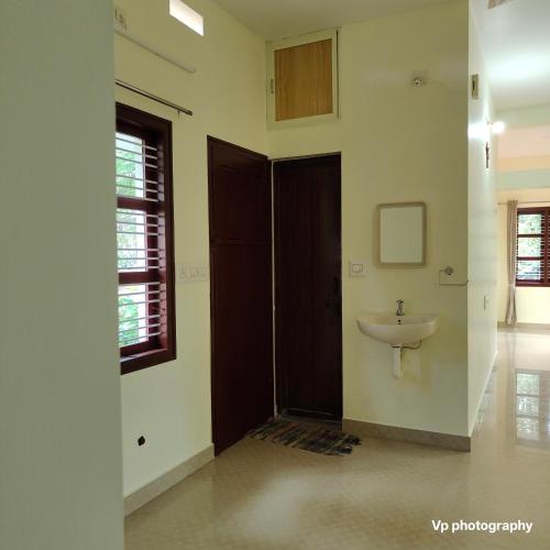 a bathroom with a sink next to a door at Trinity Mansion in Mangalore