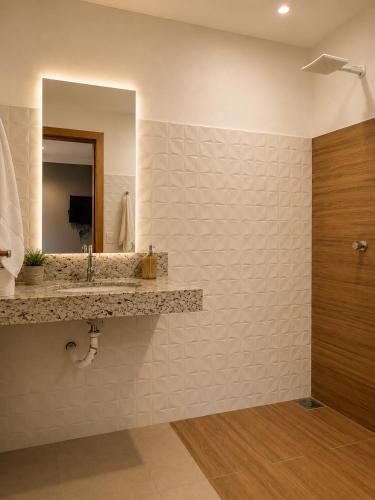 a bathroom with a sink and a mirror at Flat com Jacuzzi - Cantinho do Lago 2 in Capitólio