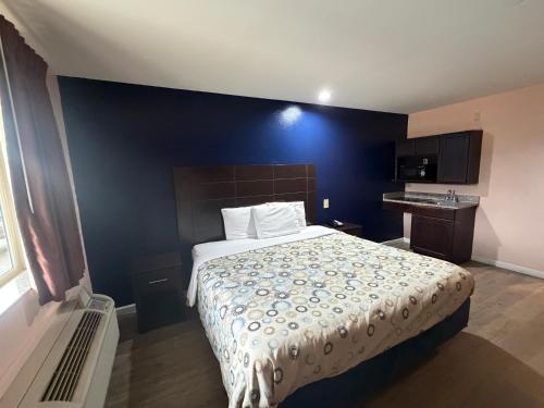 a bedroom with a bed with a blue wall at Paradise Inn & Suites in Baton Rouge