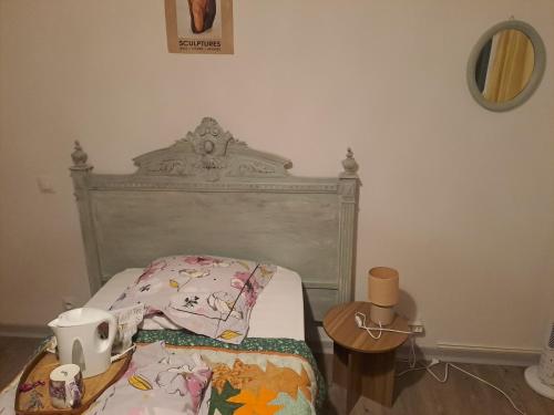 a bedroom with a bed with a headboard and a table at Le cocon in Carpentras