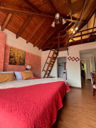 ein Schlafzimmer mit einem roten Bett und einer Treppe in der Unterkunft Hotel Volcano Baños in Baños