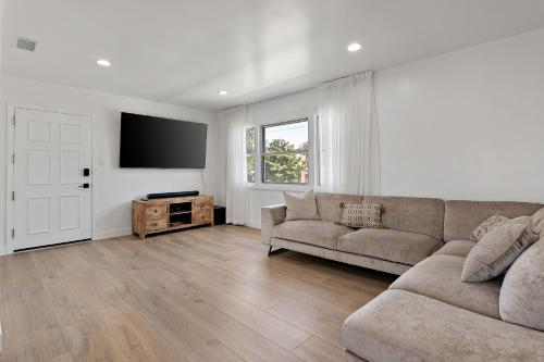 a living room with a couch and a flat screen tv at LA Gramercy in Los Angeles