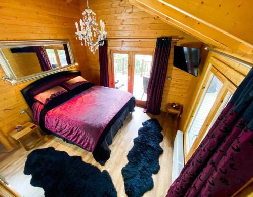 a bedroom with a bed in a wooden cabin at Kingfishers Woody Park in Willand