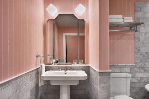 a bathroom with a sink and a toilet and a mirror at Riggs Washington DC in Washington, D.C.