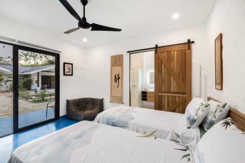 a bedroom with two beds and a ceiling fan at Villa Peuchere in Santa Cruz