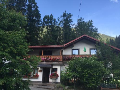 a house with a balcony with flowers on it at Waldhaus in Hinterstoder