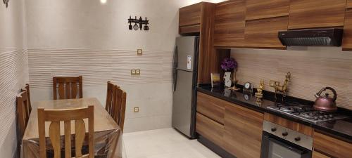 a kitchen with a table and a stove and a refrigerator at تاركة مراكش in Marrakesh