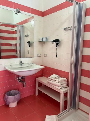 a bathroom with a sink and red and white stripes at B&B Torre del Lago 1 in Foce Varano