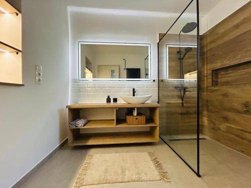 a bathroom with a sink and a mirror at Gabi Apartman in Gyenesdiás
