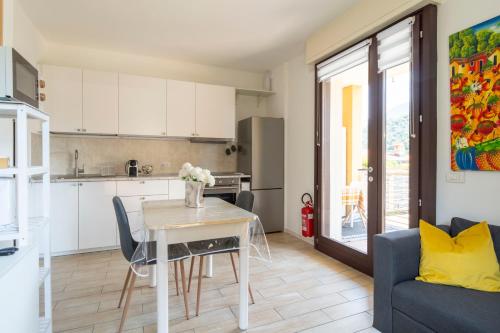 a kitchen and living room with a table and a couch at Pepita del Lago - Piscina e Parcheggio privato in Lenno