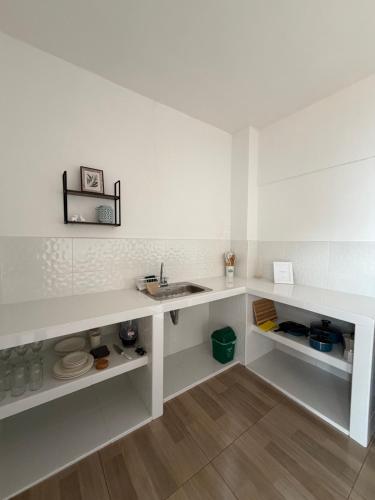 a white kitchen with a sink and a counter at Casa Natus Hostal in Zapatoca