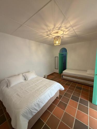 a bedroom with a bed and a window and a couch at Casa Natus Hostal in Zapatoca