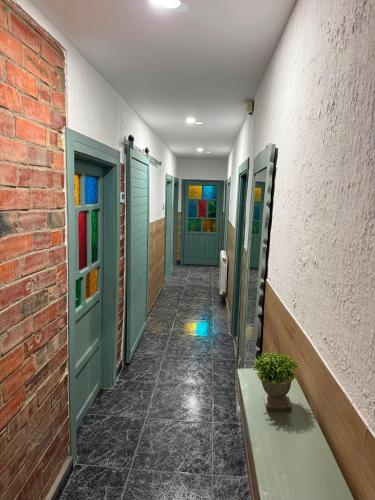 a hallway with green doors and a brick wall at La casa de Ángel in Llombera
